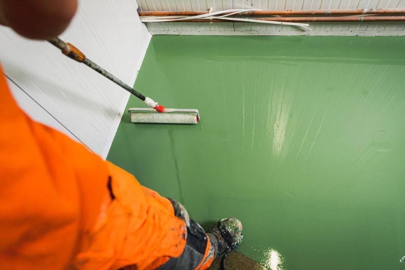 worker levelling epoxy on the garage floor