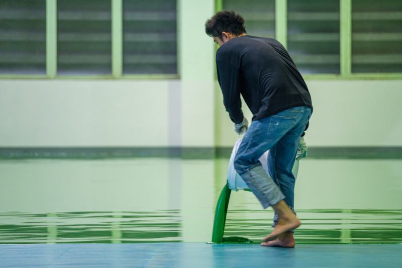 worker pouring epoxy floor mixture