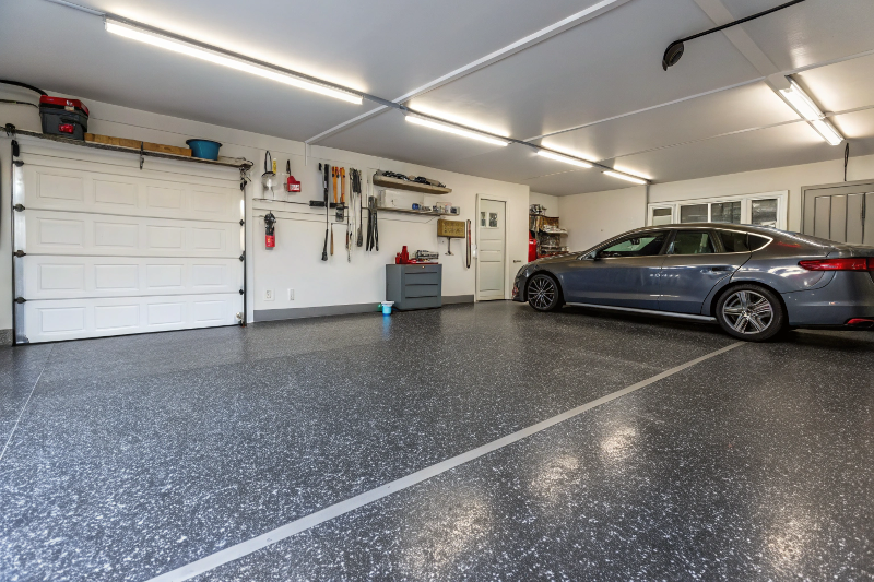 Refinished residential garage floor in Ipswich with charcoal grey epoxy coating and decorative flakes